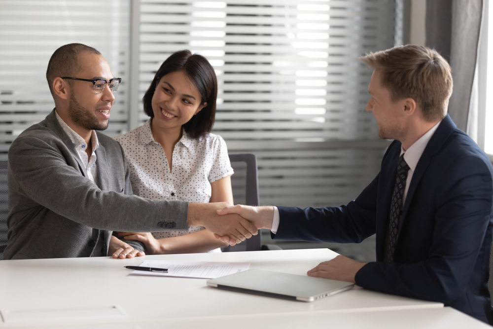 the wealthy family shaking hands with their CPA after providing financial reporting and risk managment
