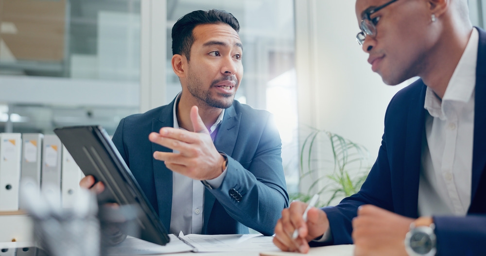 Business owner and accountant in meeting with tablet for info, planning and investment in office. Collaboration, in workplace.